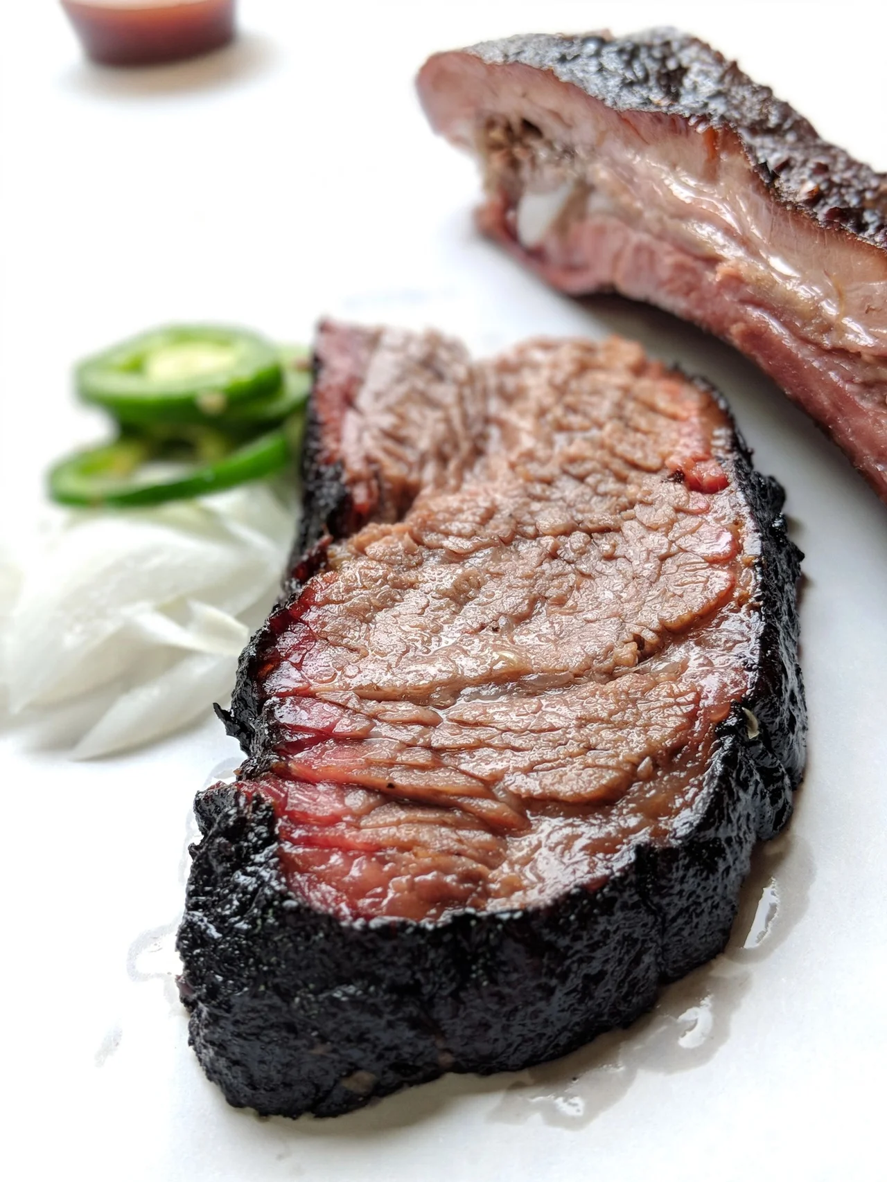 Sliced prime brisket with peppery bark and a pink smoke ring
