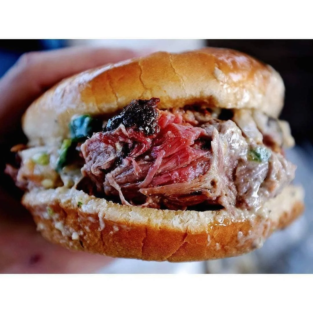 Close-up of CorkScrew’s brisket sandwich with pickles on a toasted bun